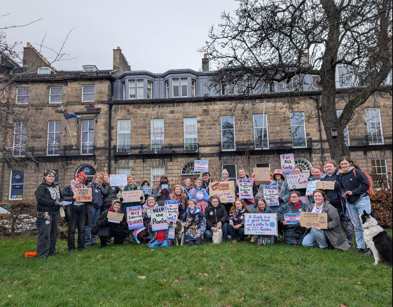 A group of about 30 protesters holding pro trans signs outside Girlguiding Scotland HQ