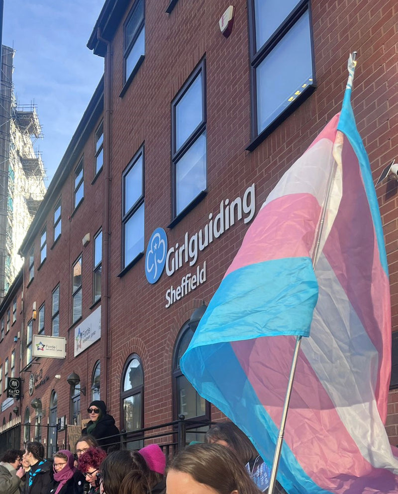 A photo of a trans flag in front of the Girlguiding Sheffield building